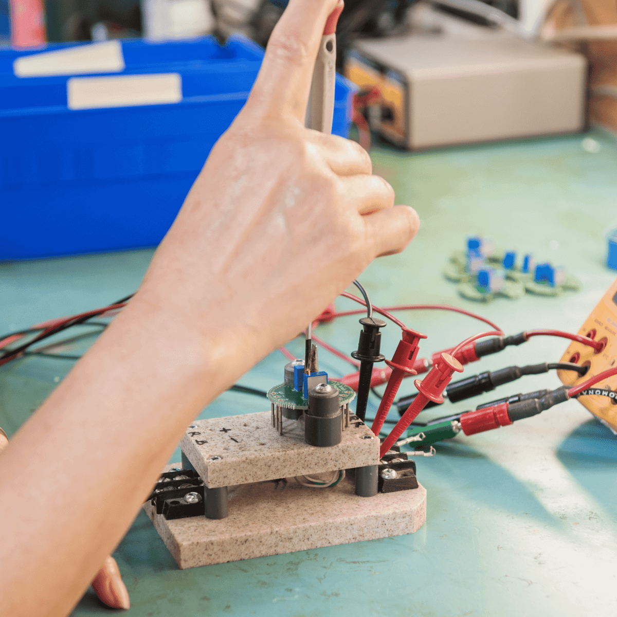 Close up of Intempco's employee fine tuning a small electronic part of our sensor.